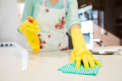 Mujer con guantes amarillas limpiando