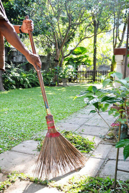 Cómo limpiar y mantener tu jardín en verano-recojiendo la hierba cortada