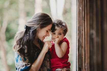 mujer con un niña en brazo jugando