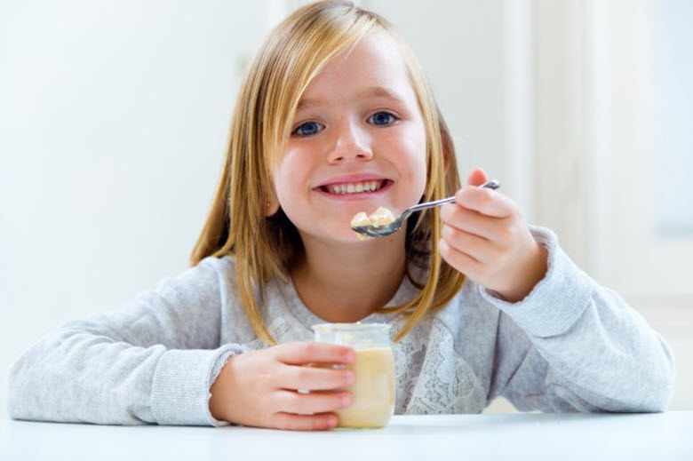 buenos hábitos a los niños-chica comiendo un yogur