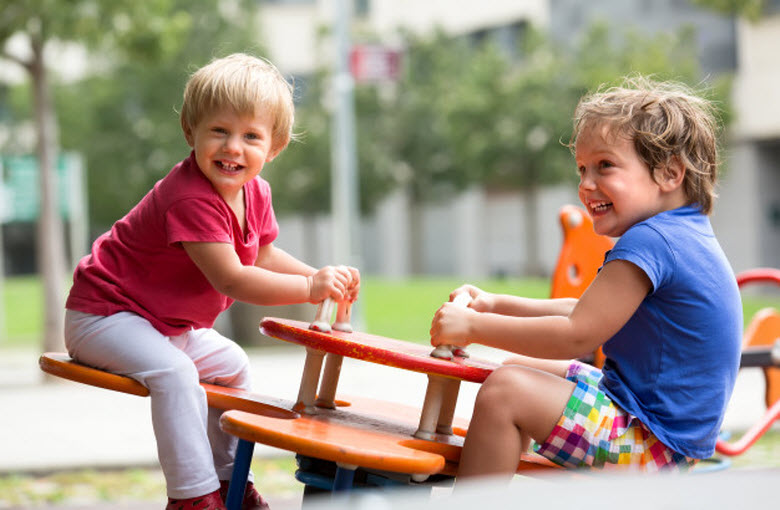 dos chicos en el columpio del parque infantil