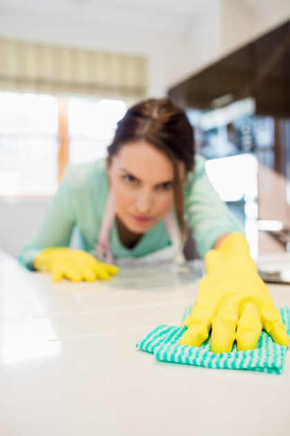 mujer limpiando la superficie de la mesa