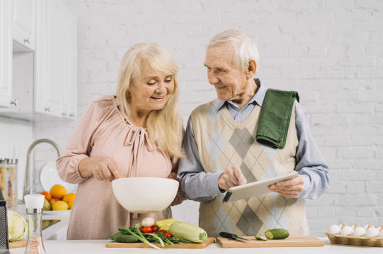 pareja de personas mayores cocinando juntos