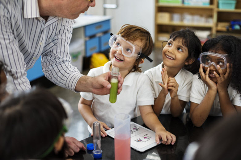 niños con gafas de protección haciendo experimento