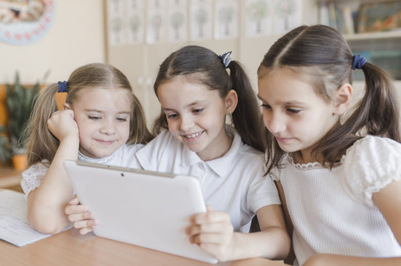 tres chicas mirando una tableta