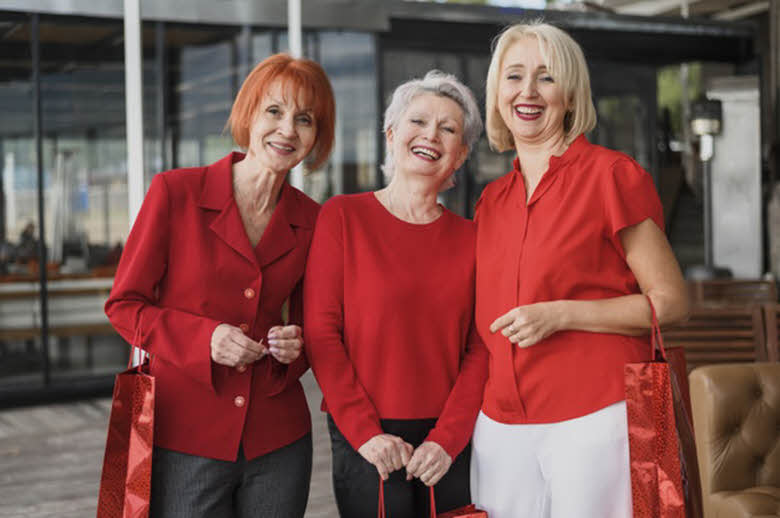 Tres mujeres riendo, vestidas de roja