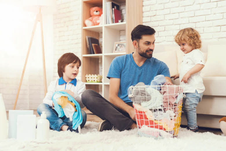 padre con sus hijos recogiendo su habitación